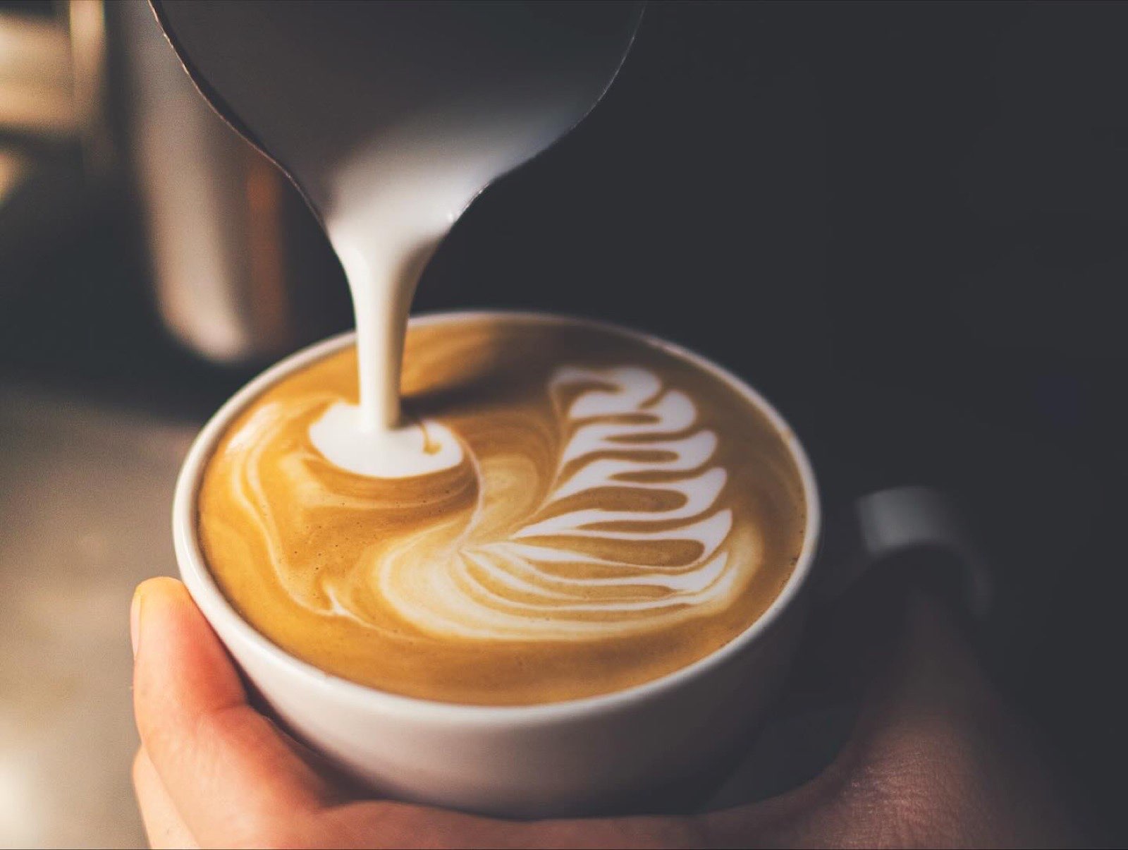 Latte art hellt í bolla